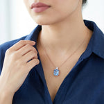 Elegant rose gold necklace featuring a sparkling blue rectangular crystal pendant with a delicate clear stone detail on a fine chain.
