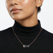 Rose gold infinity heart necklace with blue crystal accents and delicate heart charm design for women.
