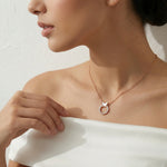 Rose gold butterfly halo necklace with sparkling circular stone pendant and delicate chain
