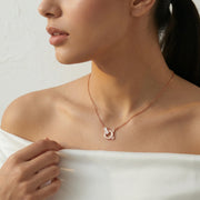 Rose gold orbit crystal necklace with circular pendant and sparkling stone accents
