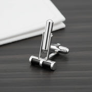 Black enamel barrel cufflinks with polished metallic finish for men’s formal wear and luxury shirt styling.
