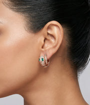 Rose gold serpent hoop earrings with emerald green stones and crystal detailing for women’s luxury jewellery styling.
