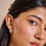 Rose gold serpent hoop earrings with emerald green stones and crystal detailing for women’s luxury jewellery styling.
