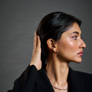 Minimal rose gold wave stud earrings with sleek sculptural curved design and polished finish
