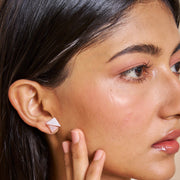 Rose gold geometric pearl stud earrings with crystal accents and modern triangular design for women.
