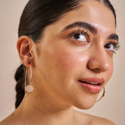 Rose gold hoop earrings with round crystal pave disc design for elegant party and everyday wear.
