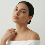 Rose gold hoop earrings with black enamel accents and crystal detailing in a modern geometric curved design for women.
