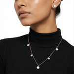 Rose gold pearl pendant necklace set with matching round stud earrings and crystal heart charm detailing on chain.
