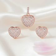 Blush heart crystal jewellery set with rose gold pendant and matching stud earrings featuring sparkling stones.
