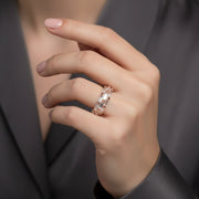Elegant rose gold eternity ring with sparkling baguette-cut crystal stones in a luxurious modern band design.
