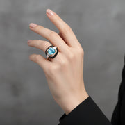 Luxury blue crystal halo ring with rose gold finish and black enamel detailing for women
