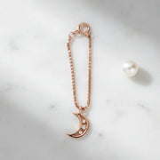 Rose gold crescent moon charm with sparkling crystal accents and chain attachment

