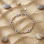 Dual tone infinity link bracelet with sparkling stone accents and rose gold detailing for women’s luxury jewellery styling.
