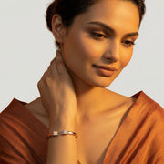 Rose gold crystal cuff bracelet with sparkling pave rectangular ends and elegant open bangle design for women.
