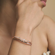 Rose gold geometric crystal cuff bracelet with sparkling round stones and modern open bangle design.
