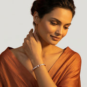 Elegant rose gold open cuff bracelet with crystal pave detailing, pearl inlay, and oval center stone design.
