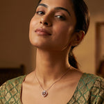 Rose gold heart pendant necklace with crystal heart detailing and modern open-heart charm design on chain necklace.

