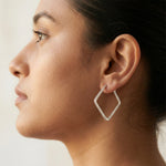 Modern square frame hoop earrings with sparkling crystal detailing and elegant silver finish for women.
