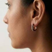 Rose gold geometric hoop earrings with black enamel detailing and sparkling crystal accents
