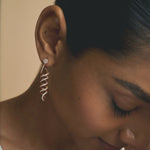 Rose gold spiral drop earrings with sparkling stone detailing and elegant twisted long dangle design for women.
