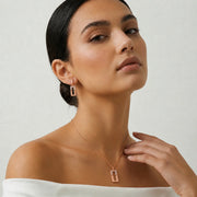 Rose gold rectangle pendant set with baguette crystal detailing and matching drop earrings
