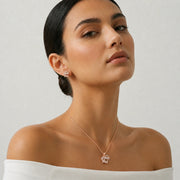 Rose gold infinity pendant and earrings set with baguette stones and sparkling crystal detailing for women.
