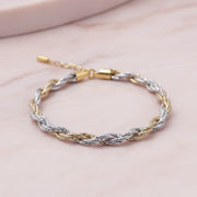 Elegant twisted rope bracelet with intertwined gold and silver tone chain design for women
