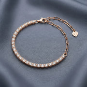 Rose gold crystal tennis bracelet with sparkling stones and adjustable chain clasp
