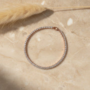 Luxury radiant rose gold tennis bracelet with sparkling crystal stones and elegant clasp design isolated
