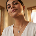 Elegant floral pendant necklace with soft grey petals and sparkling crystal accents on a silver chain.
