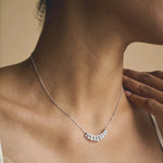 Elegant silver tone baguette crystal fan necklace with curved pendant design on delicate chain for women’s luxury fashion jewelry.
