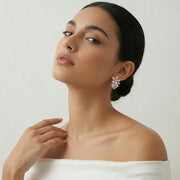 Blush floral crystal earrings with rose gold finish and sparkling square-cut stones for elegant party wear styling.
