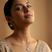 Moonlit floral circle jewelry set with matching pendant necklace and hoop earrings featuring white flower charms and crystal accents.
